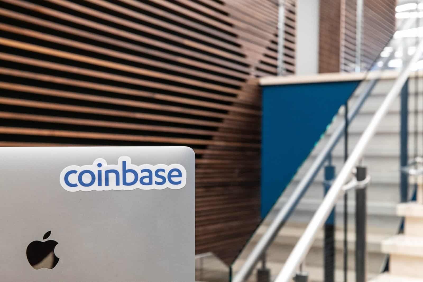 Coinbase office with company logo sticker on MacBook laptop, representing the exchange brand and corporate presence