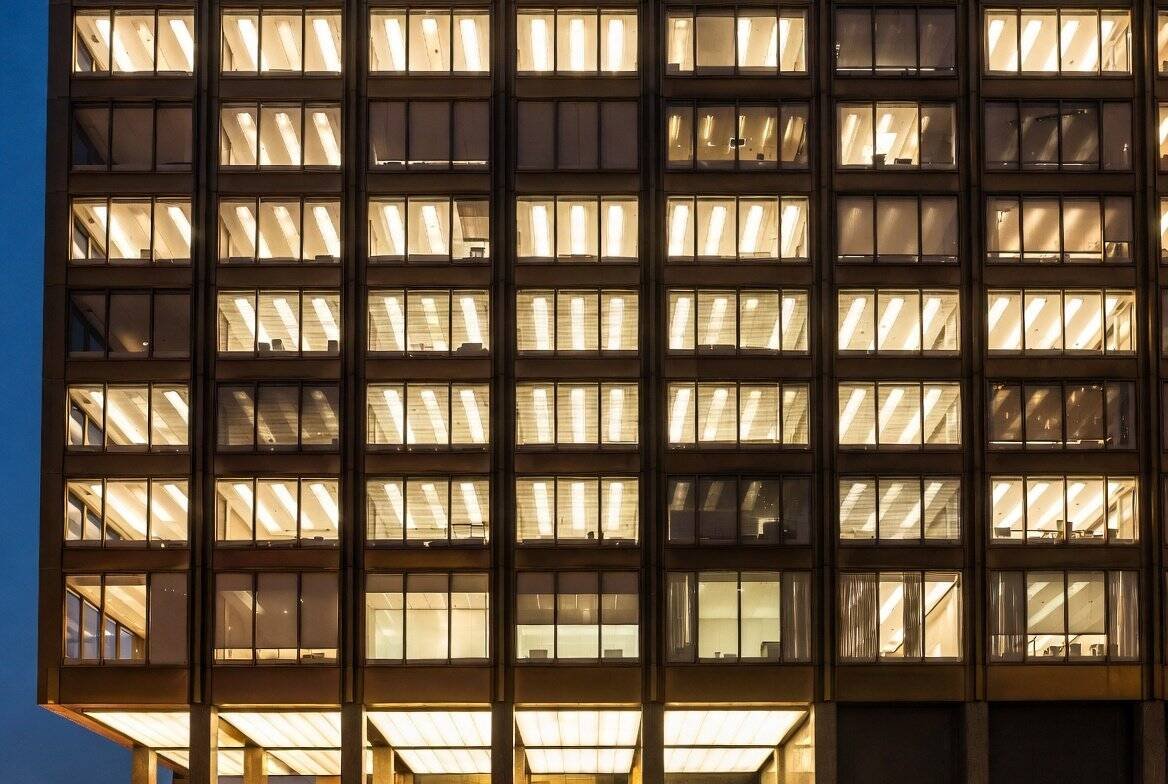 Modernist glass building illuminated at night symbolizing institutional Ethereum investment and NYSE trading
